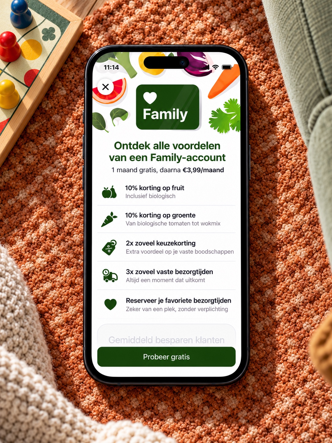 Picnic Family membership app on a phone photographed overhead on a living-room rug beside a board game